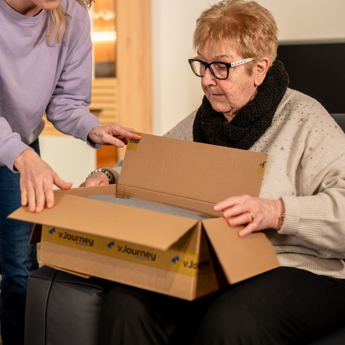 Seniorin packt das vJourney-Mietpaket aus